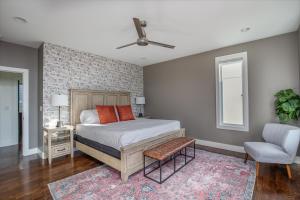 um quarto com uma cama e uma parede de tijolos em Jack Daniels House with Rooftop Golf, City views! 8min to Whiskey Row! Sleeps 10! em Nashville