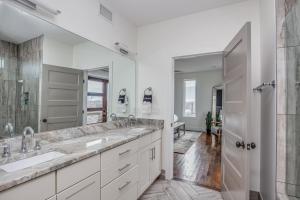 un bagno con due lavandini e un grande specchio di Whiskey House with Rooftop Golf, City views! 8min to Downtown! Sleeps 9! a Nashville