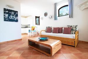 a living room with a couch and a table at Villa Titina - Sunset Apartments in Ischia