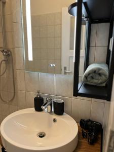 uma casa de banho com um lavatório branco e um espelho. em Easy and Cozy em Duisburg
