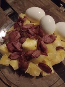 un plato de comida con huevos y tocino. en Suíte beija-flor en Camaçari