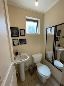 y baño con aseo, lavabo y espejo. en Espectacular Casa con 3D/3B, en Los Ángeles