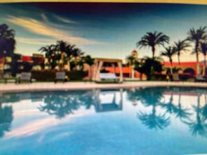 une grande piscine avec des palmiers en arrière-plan dans l'établissement HOTEL LORETO BAY, à Loreto