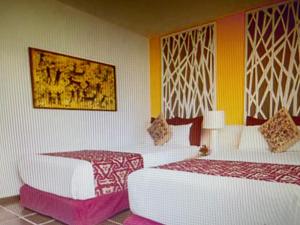 - une chambre avec 2 lits et un tableau mural dans l'établissement HOTEL LORETO BAY, à Loreto
