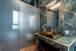 y baño con lavabo y espejo. en Royal Gold City Suites by Estia, en Heraclión
