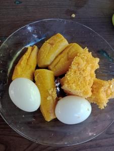 Suíte beija-flor في كامساري: صحن زجاجي عليه بيض وخبز على طاولة