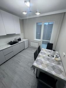 a kitchen and dining room with a table and chairs at Miami in Taldykolʼ