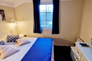 een slaapkamer met een bed met blauwe lakens en een raam bij "O'REFUGE" Maison, 4 personnes, au cœur d'un golf 18 trous, accès piscines gratuit in Talmont