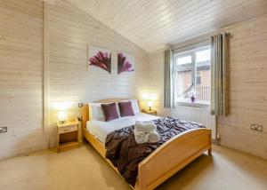 a bedroom with a bed with two towels on it at Ruby Country Lodges in Beaworthy