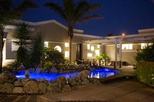 a house with a swimming pool at night at Kaya La Provence in Cape Town