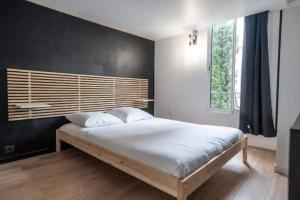 una camera con un grande letto e una parete nera di Appartement avec mezzanine a Nizza
