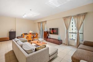 Sala de estar con 2 sofás y mesa en Cozy pad in the heart of Dubai on JBR beach!, en Dubái