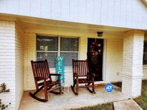 two chairs sitting on the front porch of a house at Cozy quiet retreat. in Beaumont
