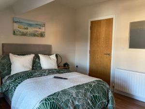 a bedroom with a bed and a wooden door at Smart 4K TVs in all bedrooms double vanity sink in Belfast