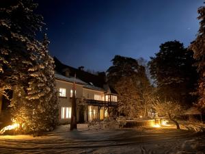 a building with lights in the snow at night at Park Residence Bei Wu in Wesenberg