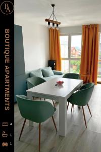 een woonkamer met een witte tafel en groene stoelen bij Boutique apartments 1 in Sînpetru