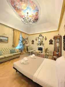 a bedroom with a large bed and a chandelier at La Baronessa in Palermo