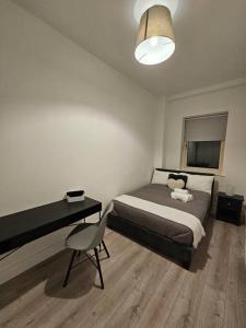 1 dormitorio con cama, escritorio y silla en Spacious and cosy house en Dublín