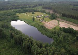 an aerial view of a farm and a lake at Meza Skuki in Vabole