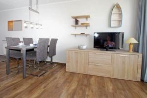 a living room with a tv and a table with chairs at Yachthafenresidenz-Wohnung-9108-882 in Kühlungsborn