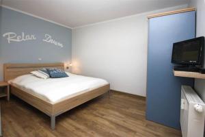 a bedroom with a bed and a flat screen tv at Yachthafenresidenz-Wohnung-9108-882 in Kühlungsborn