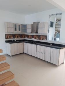 eine Küche mit weißen Schränken und einer Arbeitsplatte in der Unterkunft Casa Condominio Flandes / Giradot in Flandes