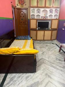 a room with two beds and a tv in it at SM Homestays 2 in Tirupati