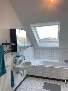 La salle de bains est pourvue d'un lavabo, d'une baignoire et d'une fenêtre. dans l'établissement Citywohnung Würselen, à Würselen