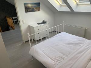 a bedroom with a white bed and a white dresser at Citywohnung Würselen in Würselen