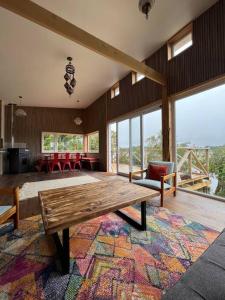 a living room with a wooden table and a large rug at Casa laguna quemchi in Quemchi