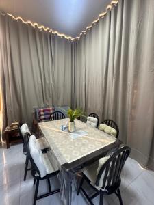 ein Esszimmer mit einem Tisch und Stühlen in der Unterkunft Cozy Mountain House Near Hatta in Sinādil