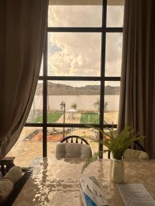 een kamer met een groot raam met uitzicht op het water bij Cozy Mountain House Near Hatta in Sinādil