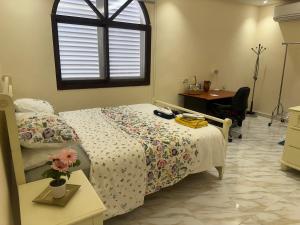 a bedroom with a bed and a desk and a window at Cozy Mountain House Near Hatta in Sinādil