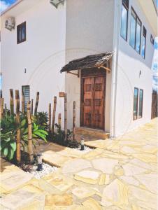 um edifício com uma porta de madeira e um pátio de pedra em Villa Nyota Zanzibar em Kidenga