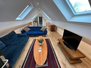 a living room with a blue couch and a table at Garage loft conversion Killinchy in Killinchy