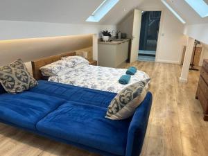 a bedroom with a blue bed and a blue couch at Garage loft conversion Killinchy in Killinchy