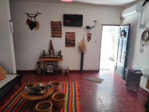 Una sala de estar con una mesa y un televisor en la pared. en Hostel, LA LULA, en Vinchina