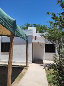un edificio blanco con una puerta y una acera en Hostel, LA LULA, en Vinchina