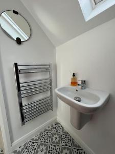 a white bathroom with a sink and a mirror at Garage loft conversion Killinchy in Killinchy