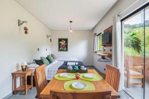 a living room with a table and a couch at Studios Pinhal in Santo Antônio do Pinhal