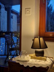 una lámpara en una mesa junto a una ventana en Hostel - F en Gjakove