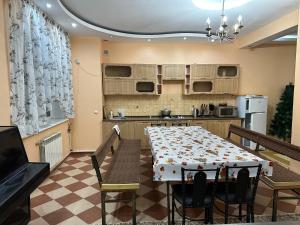een keuken met een tafel en stoelen en een keuken met een tafel en een keuken bij Горная Сказка in Besqaynar