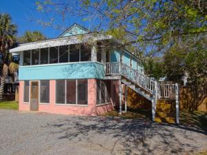 a pink and blue house with a deck at Changes In Latitudes in Folly Beach