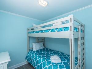 a bedroom with a bunk bed with blue walls at Changes In Latitudes in Folly Beach