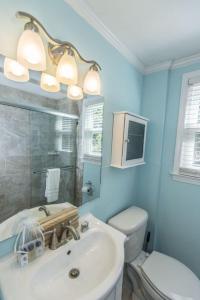 a bathroom with a sink and a toilet and a mirror at Changes In Latitudes in Folly Beach