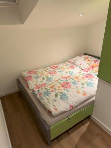 a bedroom with a bed with a floral comforter at Schwalbennest Monteurwohnung in Korbach