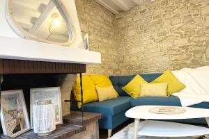 uma sala de estar com um sofá azul e almofadas amarelas em Le Jardin - Pl St Sauveur - Hypercentre em Caen