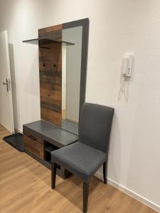 a chair in front of a desk with a mirror at Schwalbennest Monteurwohnung in Korbach