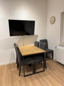 a dining room table with chairs and a flat screen tv at Schwalbennest Monteurwohnung in Korbach