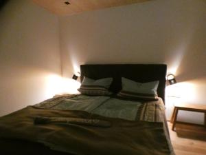 um quarto com uma cama com duas almofadas e duas luzes em Stylische Fewo in Bestlage in neugebautem Holzhaus mit Oberstaufen Plus em Oberstaufen